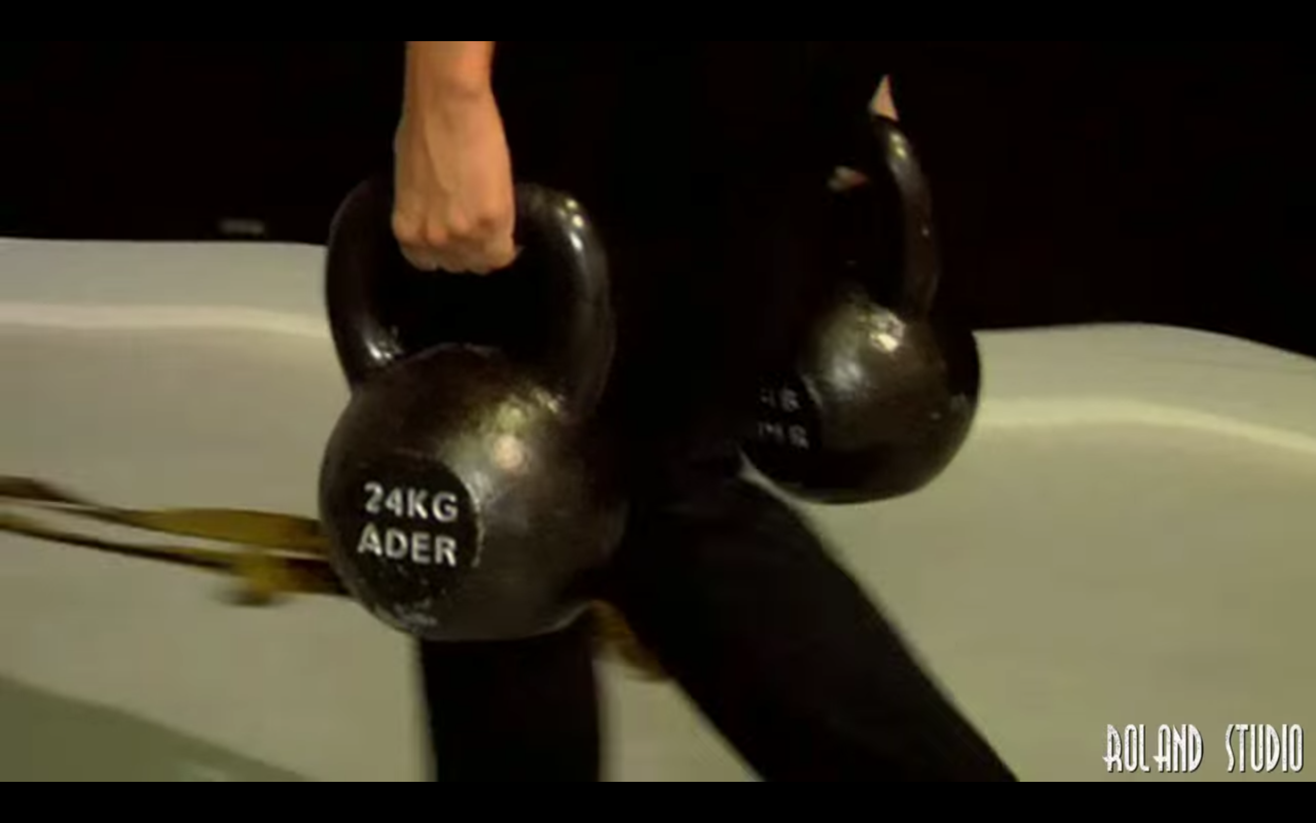 Vanessa farmer's carrying two 24kg (53 pound) kettlebells, from the Sucker Punch DVD Extraas